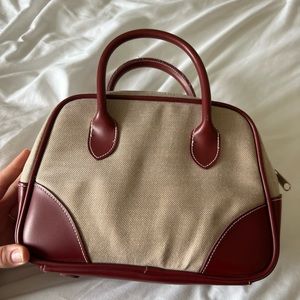 Canvas handbag with red leather accents.